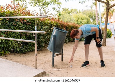 Young Urban Girl, Picking Up Rubbish From The Ground To Deposit It In A Litter Bin. Young Woman Environmentalist In City.