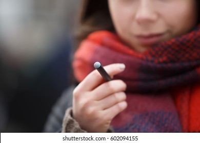 Young Vaper Girl Hold New Vape Pen Stick Cigarette In Hand.Vaping Girl Holds E-cig Device In Hand.Smoker Woman Smokes Vape Pen Ecig.Quit Smoking Cagarettes,start Vaping.Vaping Nictoine Is Bad Habbit