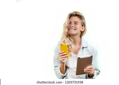 Young Very Beautiful Business Girl With A Phone And Ipad In Her Hands Smiles And Laughs At What She Saw In On A White Background