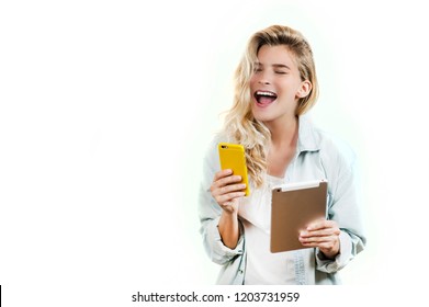 Young Very Beautiful Business Girl With A Phone And Ipad In Her Hands Smiles And Laughs At What She Saw In On A White Background