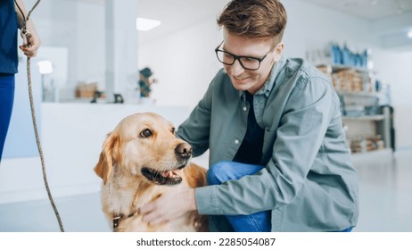 Young Veterinarian Brings a Pet Golden Retriever Back to the Guardian. A Young Man Waiting for His Pet in the Veterinary Clinic Reception Room. Dog is Happy to See the Owner and Get Petted - Powered by Shutterstock