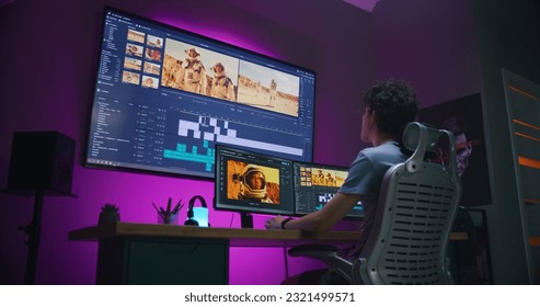 Young video maker edits movie about space mission, works at home office. Film footage and software interface with tools and sound tracks on computer and big digital screen. Concept of post production. - Shutterstock ID 2321499571