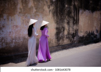 Young Vietnam woman wearing Ao Dai culture traditional walking on local street at Ho Chi Minh in Vietnam,vintage style,travel and relaxing concept.