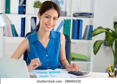 Young Vietnamese accountant working with the documents