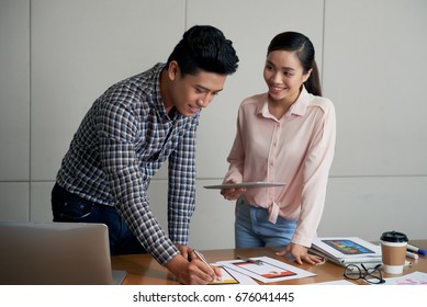 Young Vietnamese Designer And Product Manager Discussing Application Interface