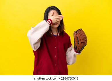 Young Vietnamese player woman with baseball glove isolated on yellow background covering eyes by hands. Do not want to see something