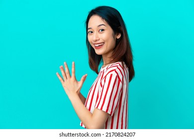 Young Vietnamese woman isolated on blue background scheming something
