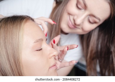 Young Visagiste Applying Face Cosmetic Primer On Model's Skin. Face Foundation For Light Fair Skin. Beauty And Make Up Salon. Small Business Concept