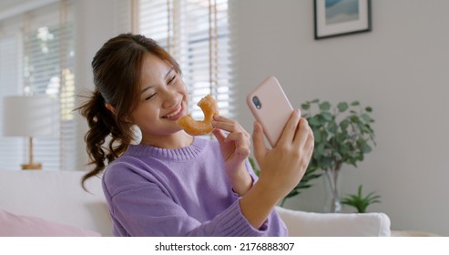 Young vlogger asia people influencer girl take photo eat bite smiley donut funny face post review on   reel app Sweet tooth food sugar lover enjoy fun show viral video camera at home - Powered by Shutterstock