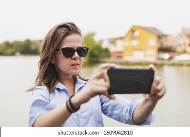 Young Vlogger Recording A Video For Her Next Social Media Event - Woman Holding Mobile Camera Horizontally While Recording Her Talking Outside