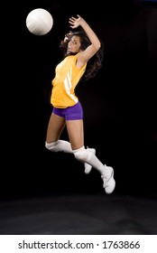 young volleyball girl in mid spike pose
