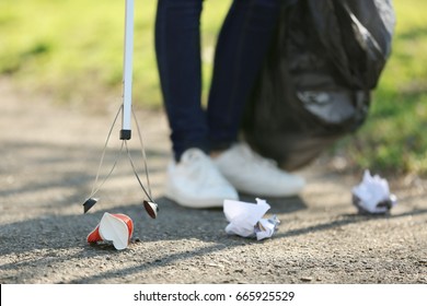 Young Volunteer Picking Up Litter In Park, Closeup