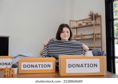 Young Volunteer Sorting Clothes for Community Donation Concept of Charitable Giving and Social Responsibility - Powered by Shutterstock