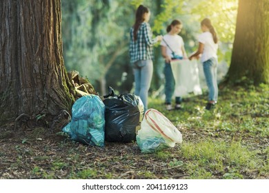 Junge Freiwillige, die den Wald säubern, Mülleimer in Mülltüten einführen, Umweltschutzkonzept
