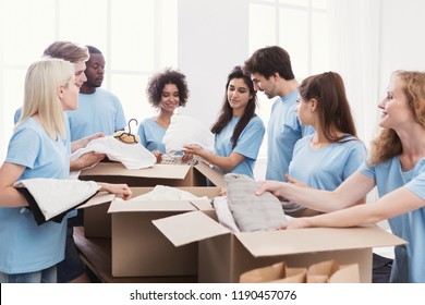 Young volunteers group sorting clothing donations in cardboard boxes, copy space - Powered by Shutterstock