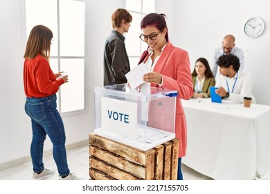 Young Voter Woman Smiling Happy Putting Vote In Voting Box At Electoral Center.