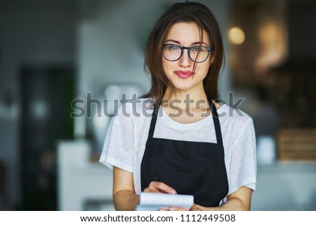 young waitress ready to take order on notepad in restauran