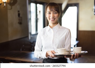 Young Waitress Serving Coffee At Cafe