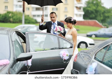 Young Wedding Couple Getting In A Car 