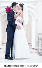 Young Wedding Couple Kissing. Bright White Colors.