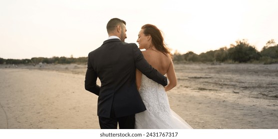 Young wedding couple portrait walking together outdoors on the beach. - Powered by Shutterstock