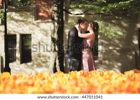 Young wedding couple posing near tree with flowers