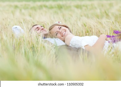 Young Wedding Couple Walking On Field.