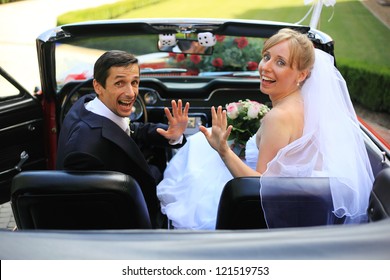 Young Wedding Couple Waving In Cabriolet Car