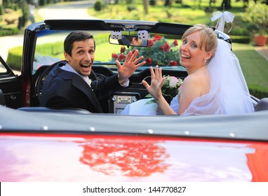 Young Wedding Couple Waving In Cabriolet Car