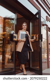 Young Well Dressed Smiling Business Woman With Tablet Pc Leaving Building, Summer Day Outdoors