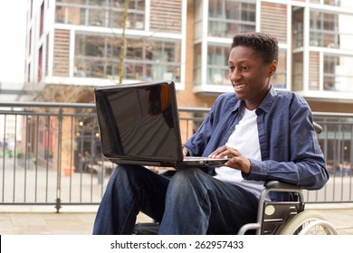 a young wheelchair user working on a laptop.