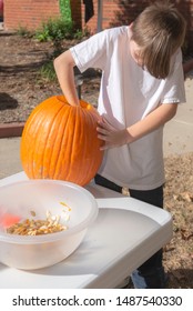 Young White Caucasian Boy Carving Pumpkin Outside