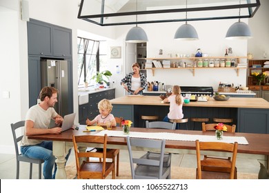 Young White Family Busy In Their Kitchen, Elevated View