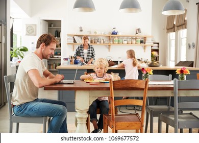 Young White Family Busy Working In Their Kitchen