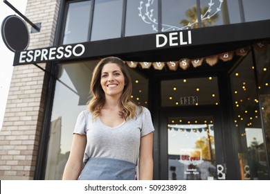 Young White Female Business Owner Standing Outside Cafe