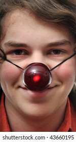 Young White Male Caucasian Teenager With A Strap On Reindeer Glowing Red Nose Ball.