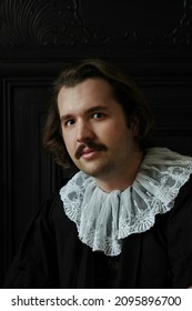 A Young White Male With Mustache On White Lace Collar On Black Background 