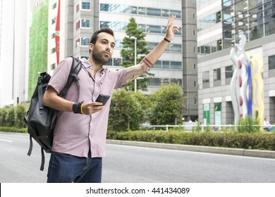 Young White Man Holding Cellphone Hailing Uber Taxi