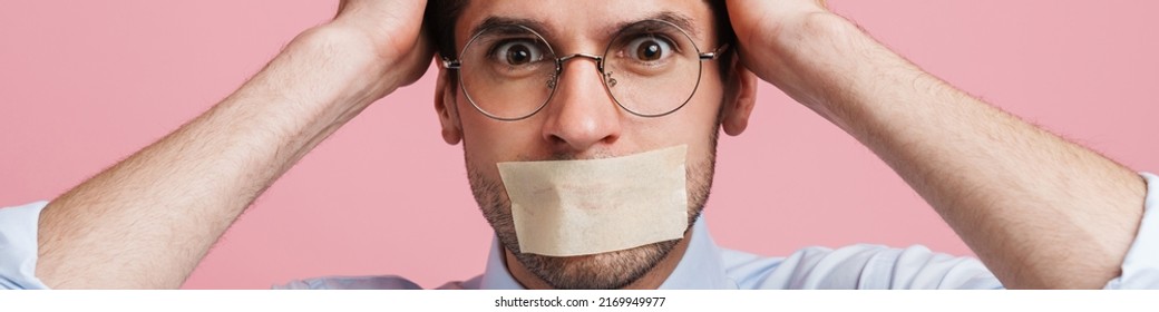 Young White Man Wearing Bow Tie Posing With Moth Glued Shut Isolated Over Pink Background