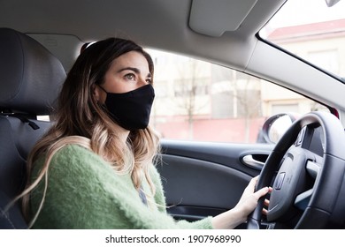 Young White Spanish Woman Wearing Protective Mask And While Driving And Green Sweater While Driving A Car. Health Care, Coronavirus, Influenza And Epidemics Driving Stills.