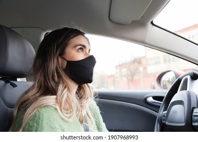 Young White Spanish Woman Wearing Protective Mask And While Driving And Green Sweater While Driving A Car Looking In The Mirror. Health Care, Coronavirus, Influenza And Epidemics Driving Stills. 