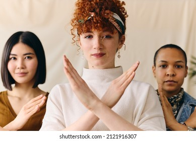 Young white woman gesturing Break The Bias in support of International Women's Day with multi ethnic female friends