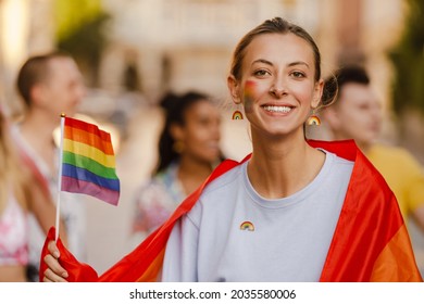 Young White Woman With Rainbow Flag Smiling During Pride Parade