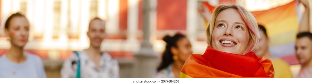 Young White Woman With Rainbow Flag Smiling During Pride Parade