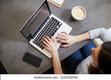 Young White Woman Using Laptop At Coffee Shop, Overhead View