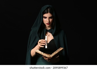 Young Witch With Spell Book And Candle On Dark Background