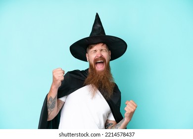 Young Wizard In Halloween Isolated On Blue Background Celebrating A Victory