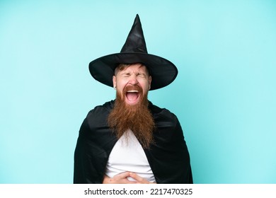 Young Wizard In Halloween Isolated On Blue Background Smiling A Lot