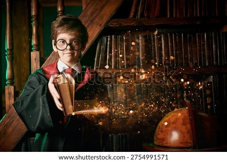 Young wizard reading ancient magic book with glowing magical sparks in fantasy library interior. Magic school and spell casting concept.