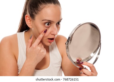 Young Woma Pulling Down Her Eyelid In The Mirror